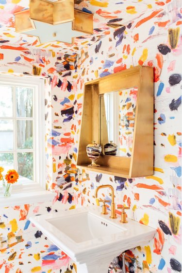 Powder room with colorful painted bathroom wallpaper and pedestal sink