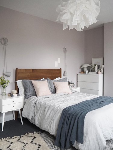 blush pink bedroom with blue bedding and white pendant