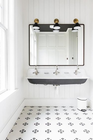 black and white patterned tile bathroom with trough sink