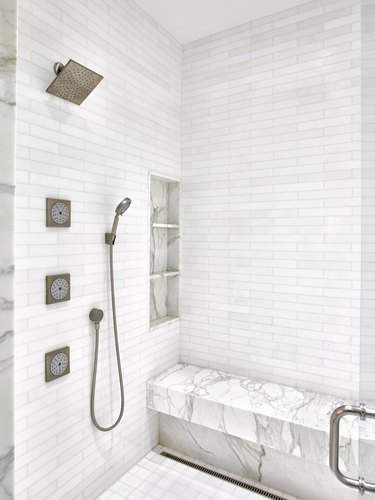 White marble shower with body sprays and handheld showerhead