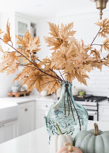 coastal fall decor with turquoise glass vase and foliage