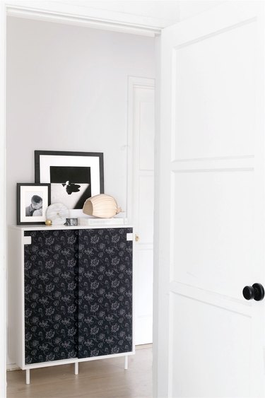 A black-wallpapered storage cabinet