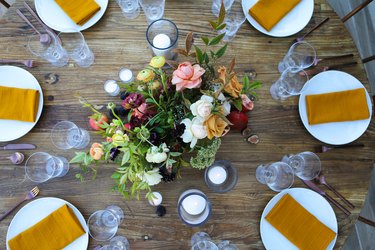 Floral centerpiece for Thanksgiving centerpieces on Tablescapes with white plates and ochre cloth napkins