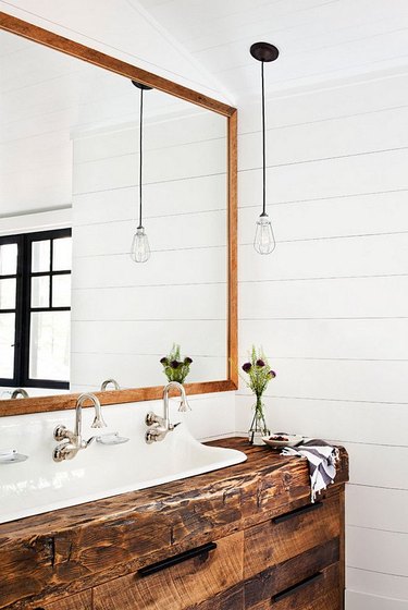 modern farmhouse bathroom with wood countertop vanity and trough sink