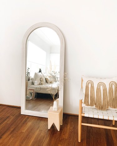 mirror, side table, chair, and pillow with tassels