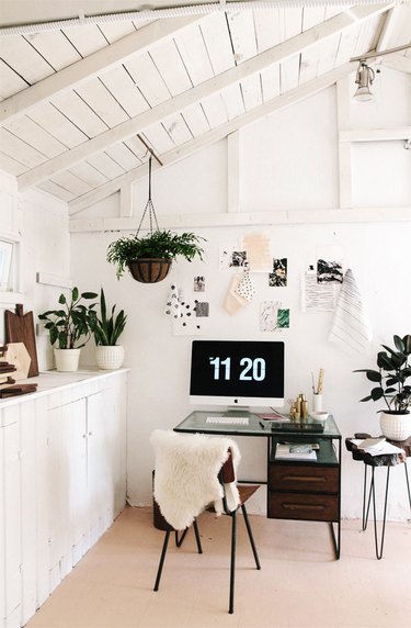 small home office with inspiration as wall art and potted plants