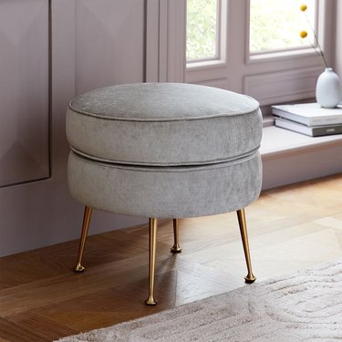 upholstered accent stool with brass legs