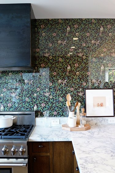 floral wallpaper kitchen backsplash with stainless steel appliances and marble countertop