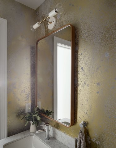 Gold wallpaper on bathroom wall