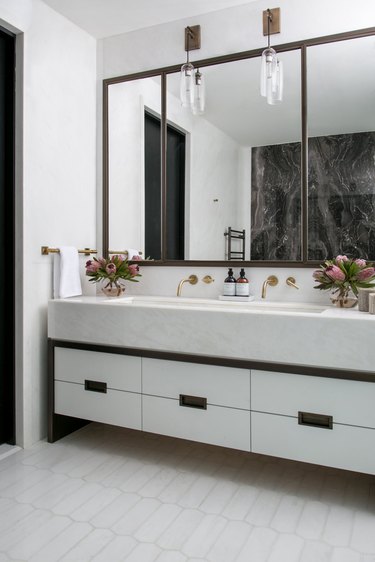 floating vanity with rectangular undermount bathroom sink and pair of brass wall-mounted faucets