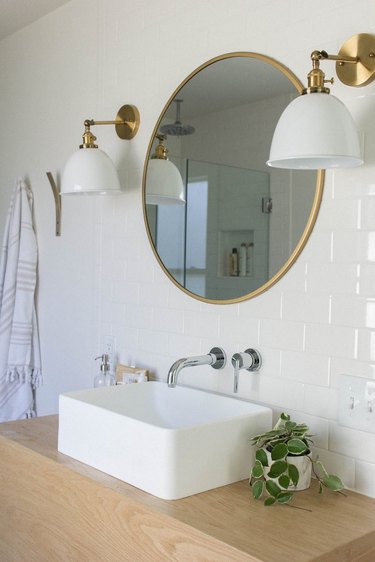 vessel bathroom sink on wood countertop with white subway wall tile