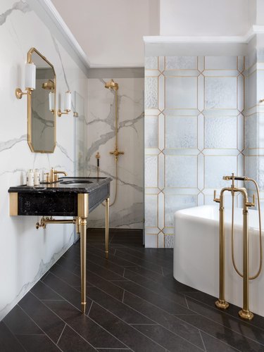 glamorous bathroom with small bathtub in the corner and console sink