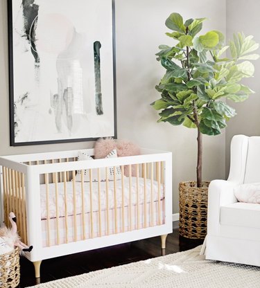 pink and white nursery with modern crib upholstered rocker and fiddle leaf fig tree