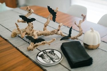 DIY branch centerpiece with bat cutouts on a table