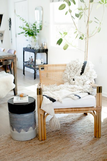 Corner of living room with textiles and rattan.