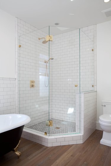 white bathroom with corner shower with glass enclosure