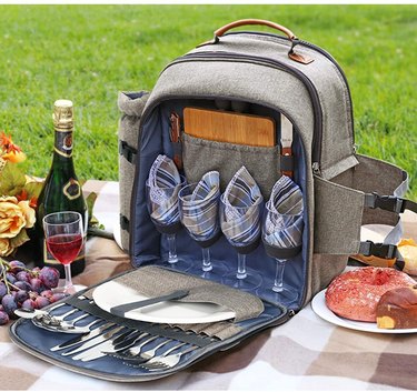 Gray backpack/picnic storage with four wine glasses, plates, and silverware