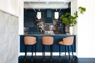 blue kitchen with tan bar stools and glossy subway tile
