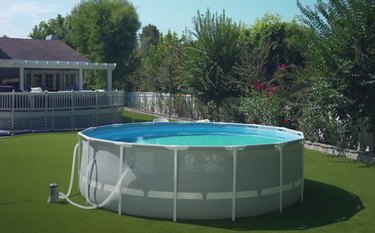 intex prism frame pool in backyard surrounded by fence and plants