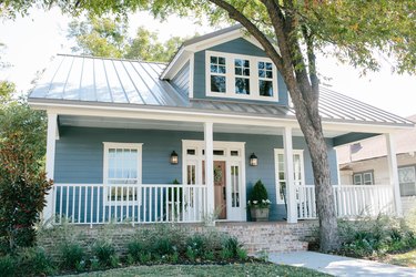 calming blue home exterior with brick skirt and metal roof