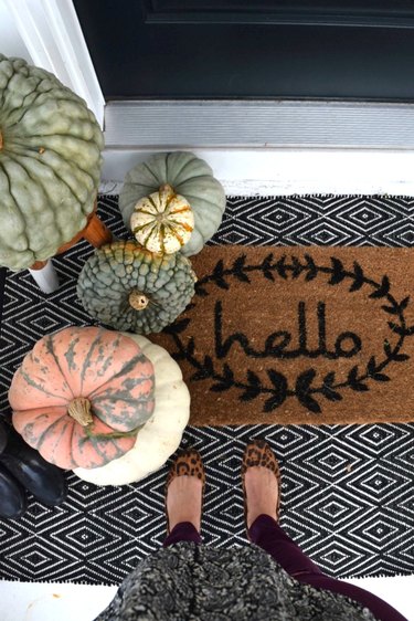 Hello fall doormat with black and white rug and pumpkins