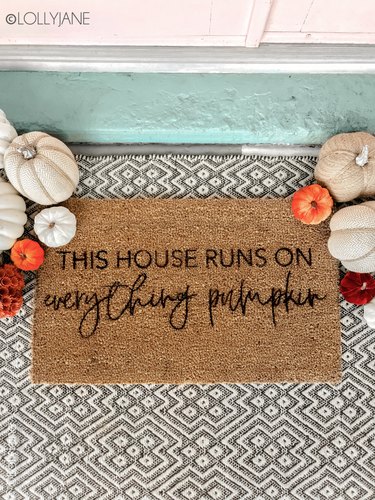 Stenciled fall doormat with patterned rug and pumpkins