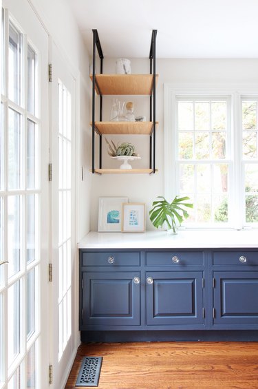 Coastal paint colors in kitchen with navy blue cabinets and open shelving