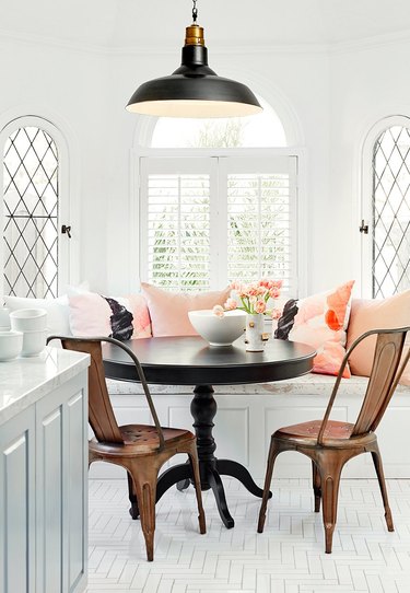 small dining room with black table and copper chairs and built-in bench