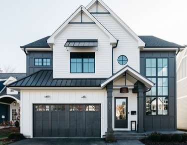 black and white farmhouse exterior with large window