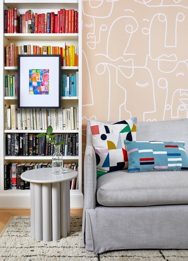 Wallpaper and color-coded books in a home office library by Zoe Feldman