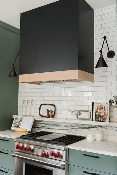 kitchen color idea with black hood and white subway tile and blue-green cabinets