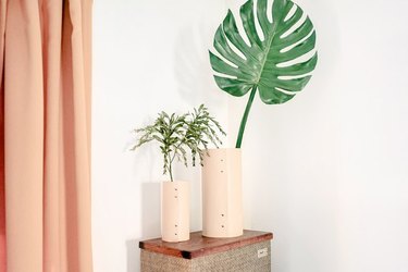 two DIY leather vases holding leaves