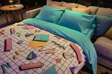 bed with bright bedding folding out from couch