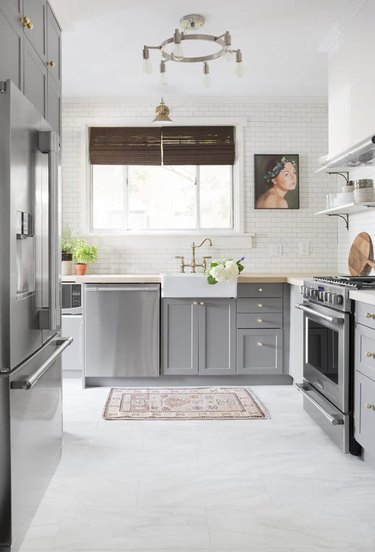 gray and white kitchen with dark gray cabinetry and marble vinyl floor