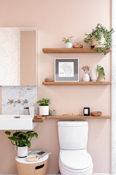 wood shelves over the toilet, pink bathroom