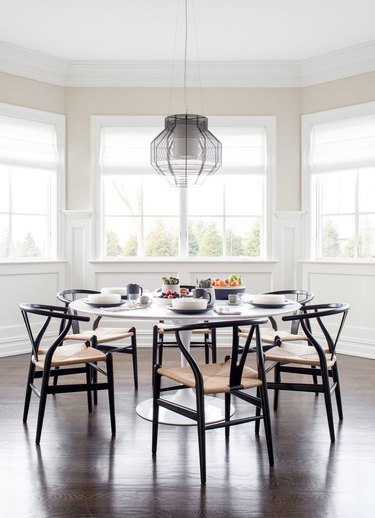 black and white dining room decor idea with wishbone chairs and bay windows