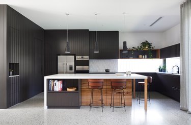black and white kitchen with black panelling and large island