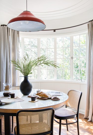 dining room curtain idea with bow window and red pendant light over table