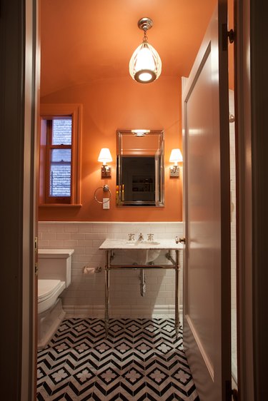 bathroom with orange ceiling and black and white tile