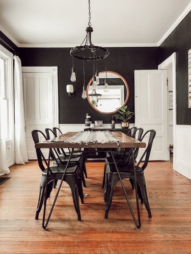 industrial dining room idea with metal chairs and rustic table and black walls