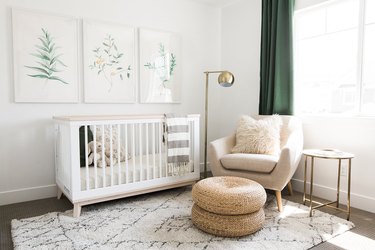 a white nursery with green drapery and nature-inspired artwork