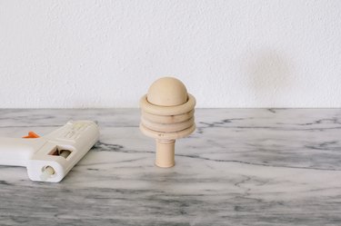 Gluing wood rings on top of wooden spools