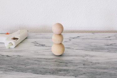 Gluing three large wooden beads together