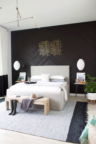 bedroom accent wall with charcoal wood panels in herringbone pattern