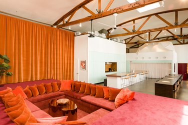 room with high ceilings and an orange curtain