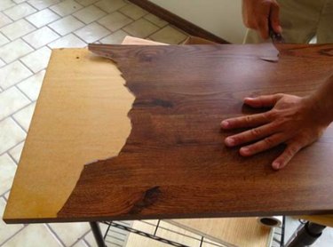 Scraping veneer off particle board.