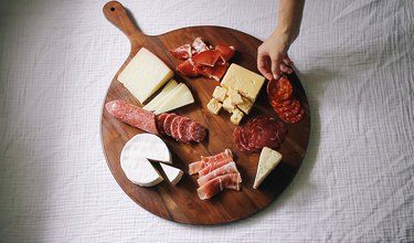 Placing the meat and cheese on the board