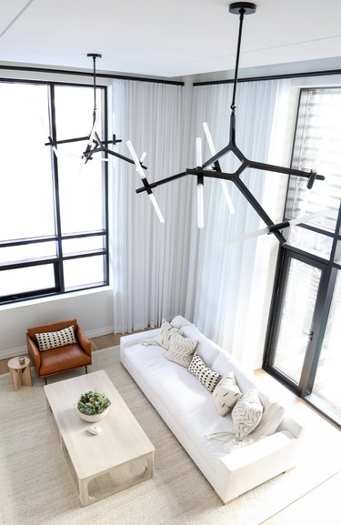 Contemporary chandeliers hung high as a pair.
