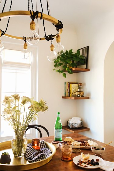 Small bohemian dining room storage idea with floating shelves