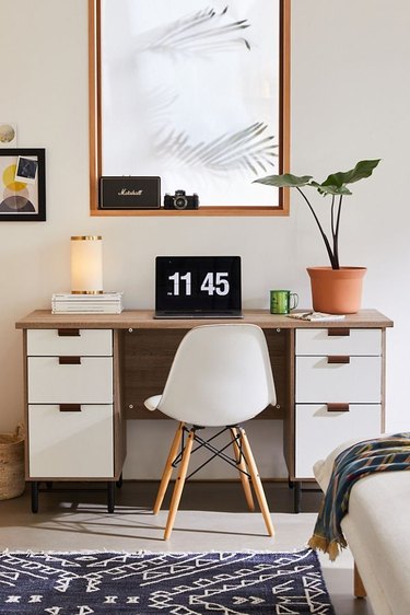 desk with plant and art print and white chair